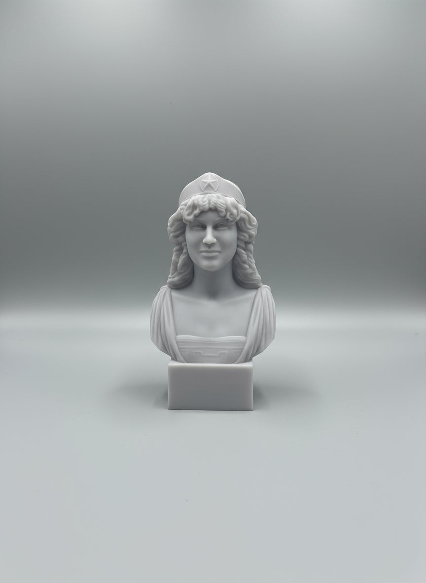 Gray stone bust on a white surface with a wooden shelf in the background